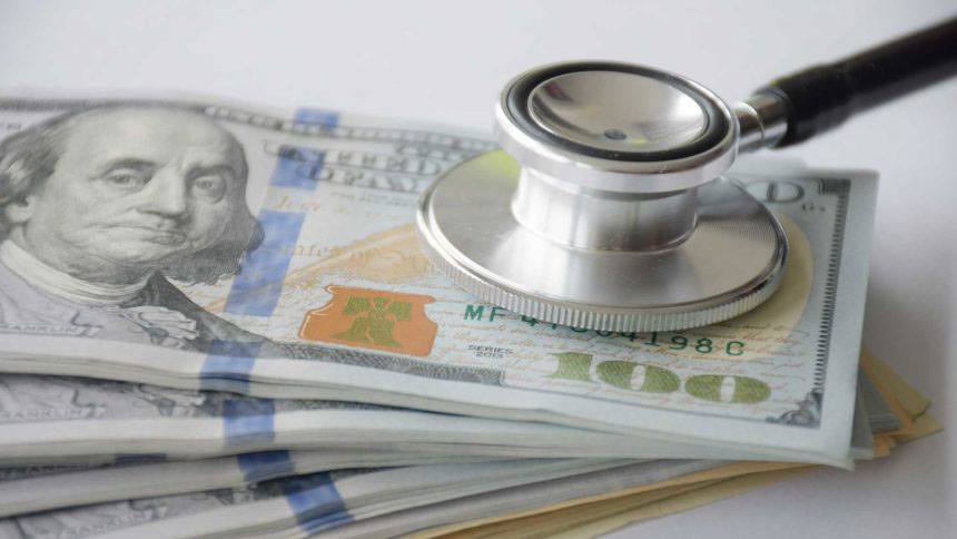 Stethoscope on money showing the big costs of long time care and the importance of insurance | Outlook Wealth Advisors